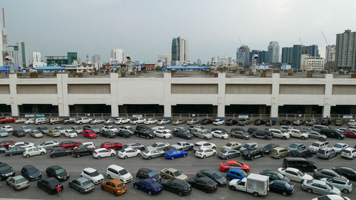 View of cars in parking lot against buildings in city