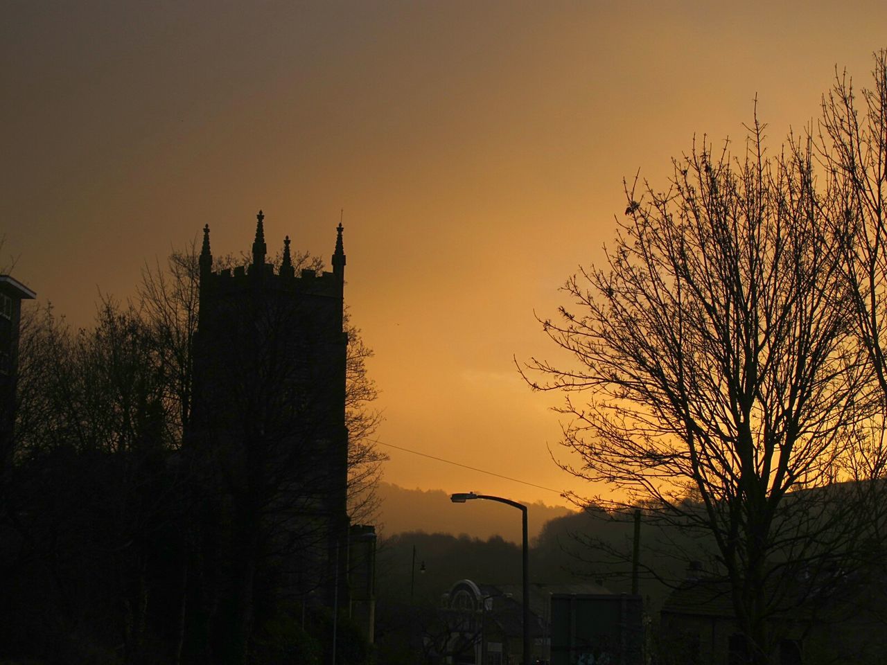 SILHOUETTE TREES AND BUILDINGS AGAINST SKY DURING SUNSET