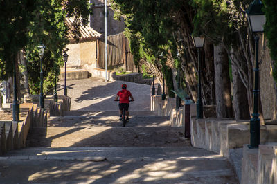 Rear view of man on bike on stairs