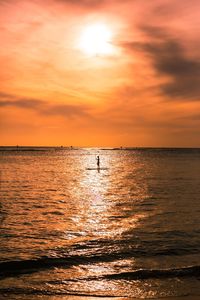 Man stand up paddle boarder paddling on ocean