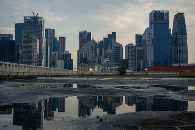 Reflection of buildings in city against sky