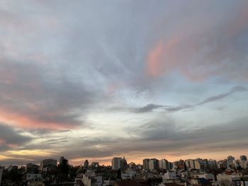 Buildings in city against sky during sunset