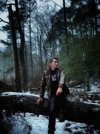 Portrait of young man standing in forest