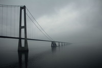 Suspension bridge over sea against sky