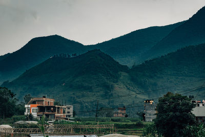 Scenic view of mountains and buildings against sky