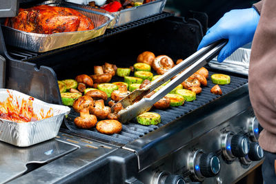 Outdoor grilling, delicious champignons and green zucchini on the grill close-up, selective focus.