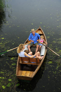 Family relaxing in rowing boat on lake