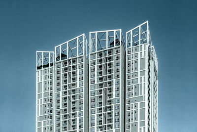 Low angle view of modern apartment building against clear blue sky