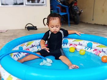 Girl playing with toy in swimming pool