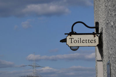 Low angle view of information sign against sky