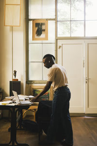 Side view of young man working at home