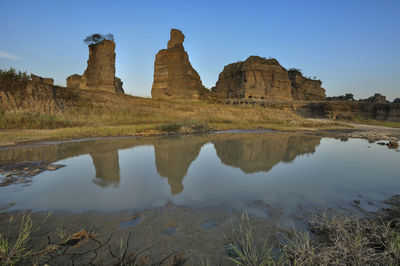 Reflection of rock formation in water against sky