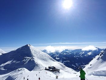 Scenic view of snowcapped mountains against blue sky