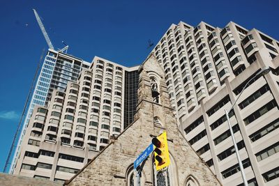 Low angle view of construction site against buildings