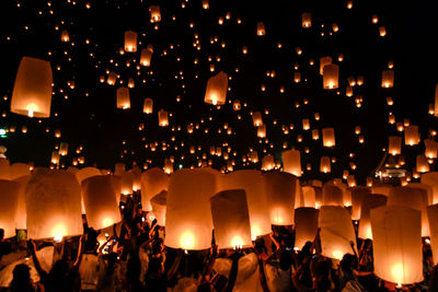 People holding paper lantern at night