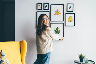 Rear view of woman standing against wall