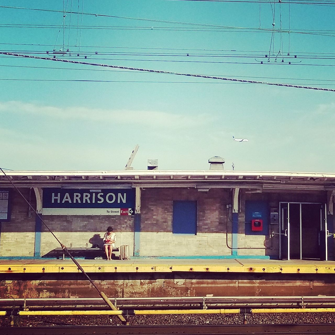 architecture, built structure, railroad track, power line, public transportation, cable, city, sky, blue, day, information sign, information, outdoors, no people, city life, power supply