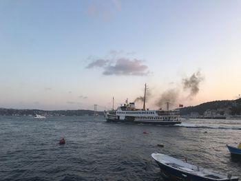 Ship sailing in sea against sky during sunset