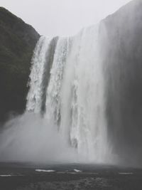 Scenic view of waterfall against sky