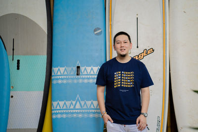 Full length of a young man standing against blue wall