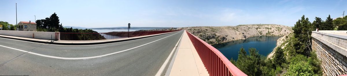 Panoramic view of road by city against sky