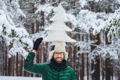 Portrait of man against snow covered trees during winter