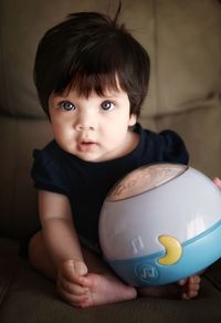 Portrait of cute baby girl with ball at home