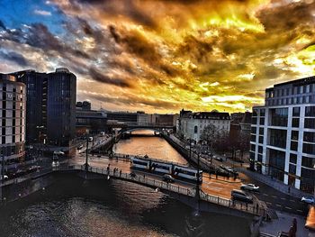 Cityscape against dramatic sky during sunset