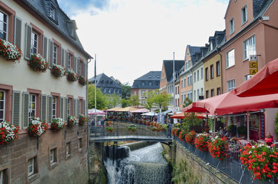 Canal amidst buildings in town against sky