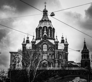 Low angle view of bell tower against cloudy sky