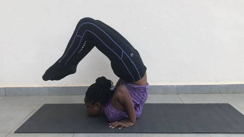 Side view of woman exercising on mat