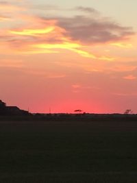 Scenic view of silhouette field against sky during sunset