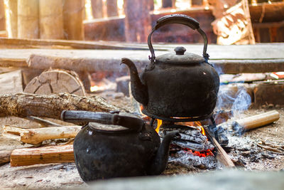 Close-up of teapots on wood burning stove