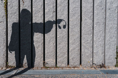 Shadow silhouette of a woman holding headphones with hand. concept of emotions and social issues