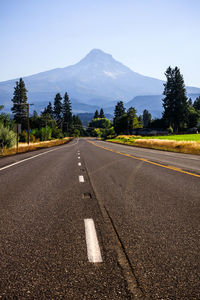 Empty road against sky during sunset