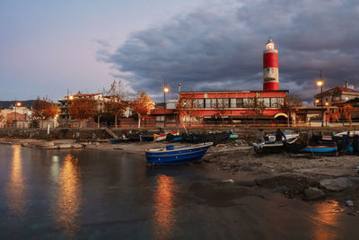 Boats in sea by buildings against sky