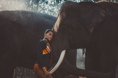 Woman standing with elephant in temple