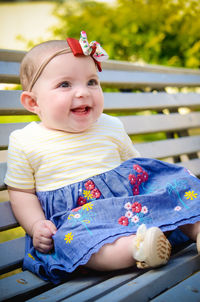 Portrait of cute baby boy sitting on sofa at home