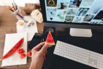 High angle view of person holding fruits on table