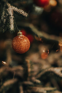 Golden shiny ball hanging on the christmas tree. new year's details in the festive atmosphere