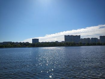 View of buildings at waterfront against blue sky