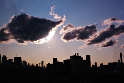 Silhouette of buildings against cloudy sky