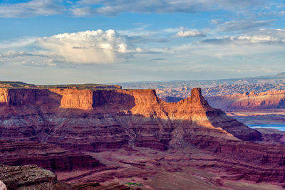 Rock formations on landscape against cloudy sky