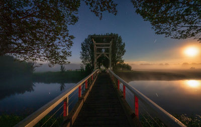 Countryside bridge over river at night