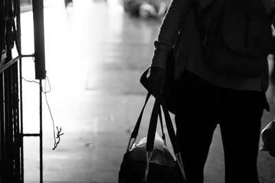 Rear view of man with luggage on street