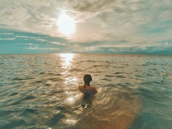 Rear view of man swimming in sea