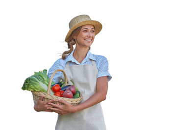 Smiling young woman holding apple against white background