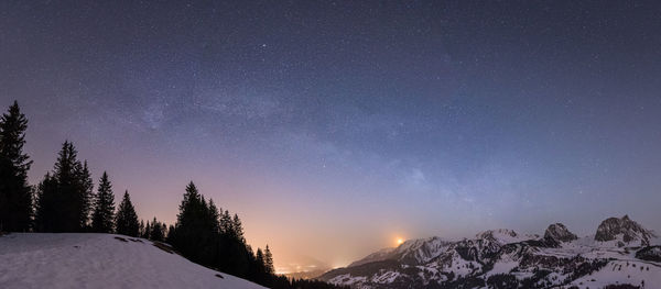 Scenic view of snowcapped mountains against sky at night