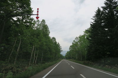 Road amidst trees against sky