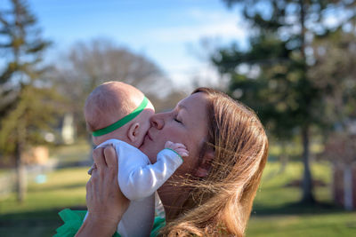 Close-up of mother carrying baby at park